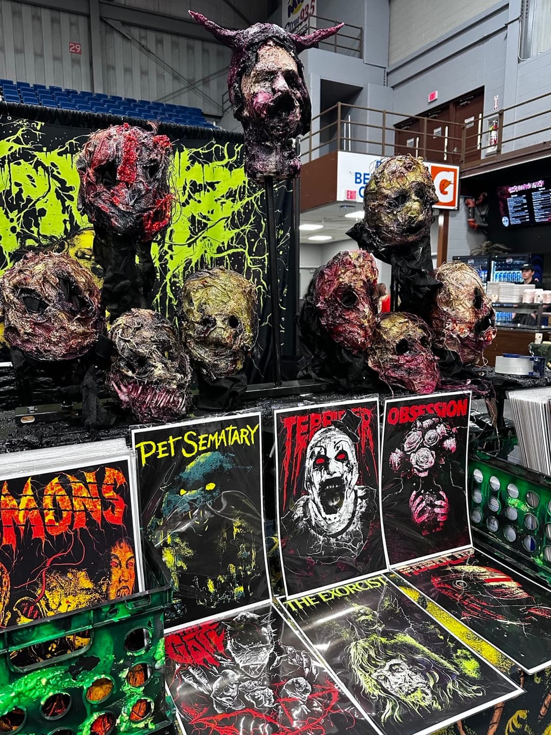 The Tomb Gallery booth at a horror convention, with sculpted heads and print racks