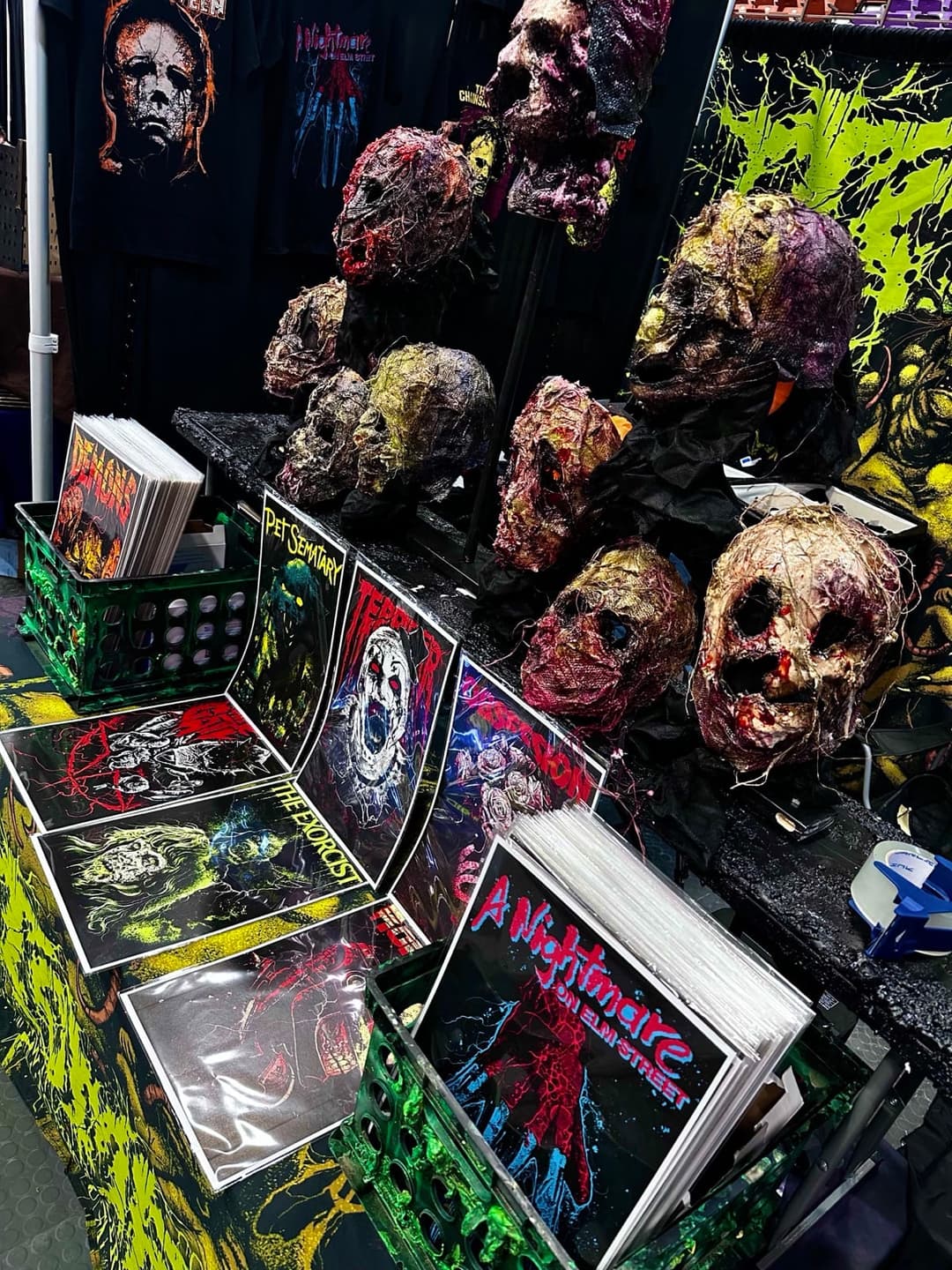 The Tomb Gallery booth at a horror convention, with sculpted heads and print racks